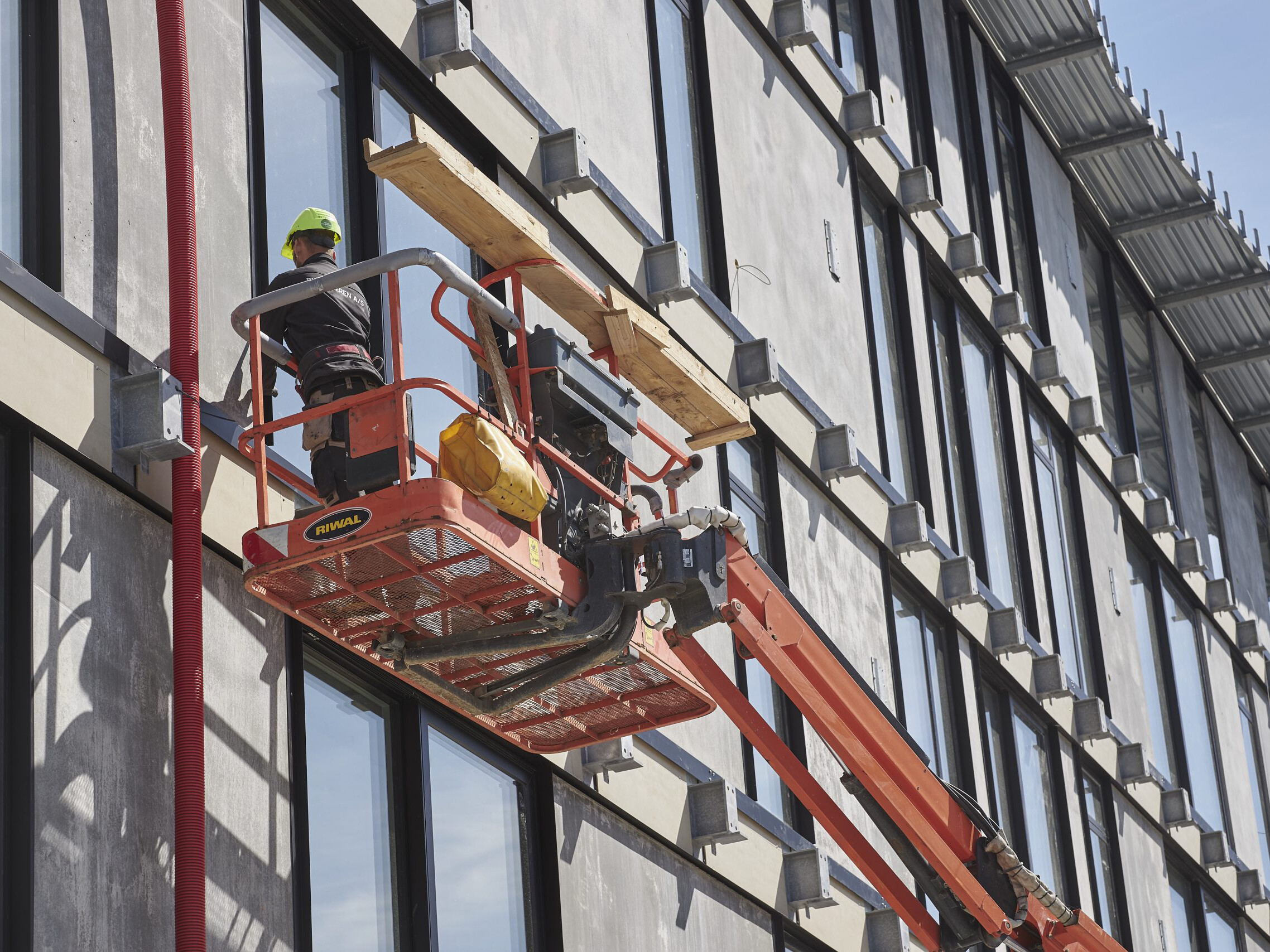T&oslash;mrere arbejde p&aring; en facade fra en lift